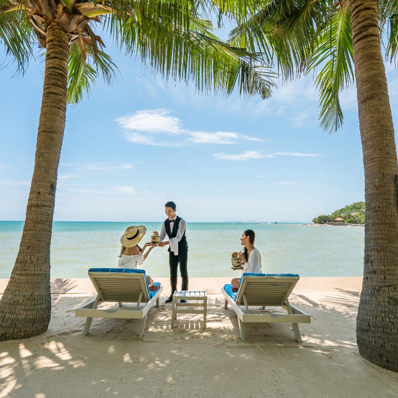 personal butler serving drinks to guests on the private beach at our ultra luxury hotel in pattaya