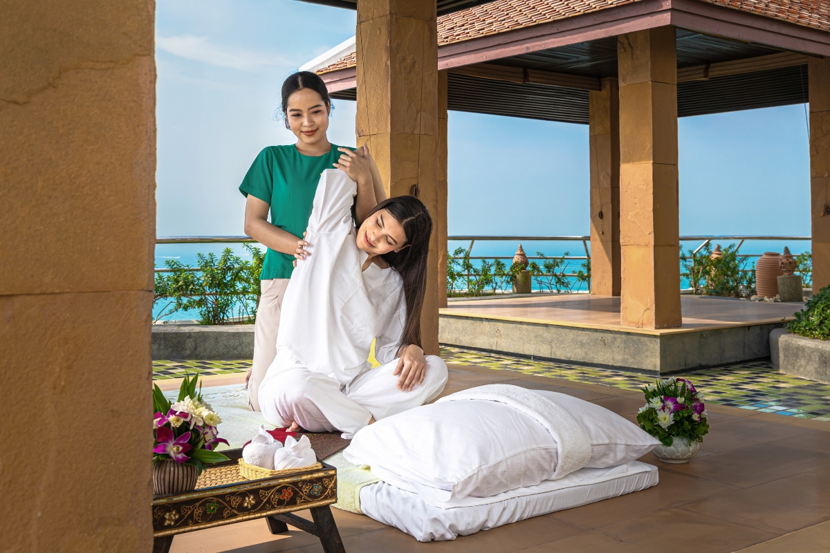 woman enjoying thai massage on rooftop of luxury hotel