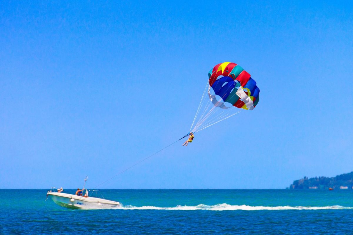 speedboat zooming on water to lift person up as they are parasailing in pattaya